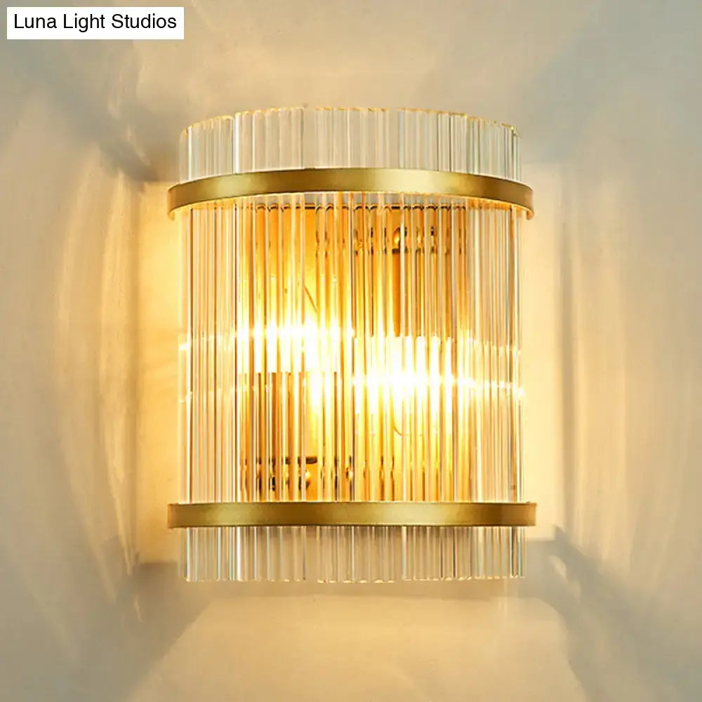 Modern gold ribbed glass living room wall mount light with vertical clear glass rods framed by brass bands