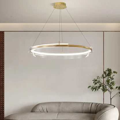 Modern gold ring chandelier pendant light with a gold-toned metal frame and clear acrylic ring for dining room decorbites