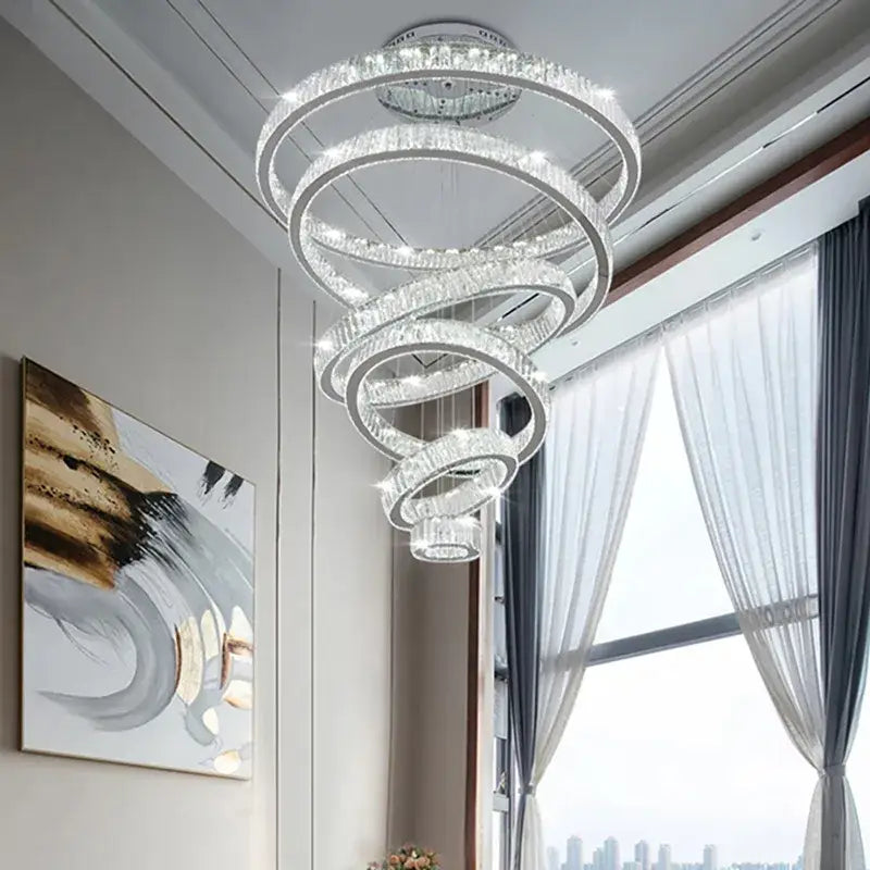A modern gold decorbites crystal led chandelier with spiral concentric crystal rings emitting elegant living room light