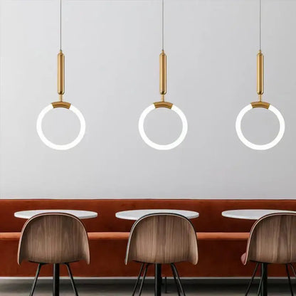 Three modern decorbites gold ring pendant lights with gold-finished cylindrical fixtures for minimalist dining room decor