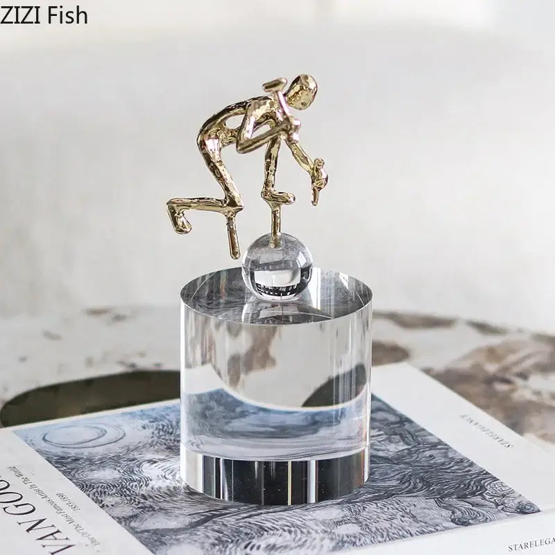 Modern gold runner crystal sculpture abstract statue featuring a gold figurine on a clear crystal sphere decorbites crystal sculpture