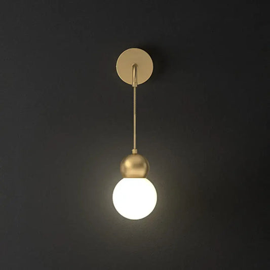 Modern gold sconce light wall lamp featuring a gold-toned spherical pendant with milky glass and minimalist fixture