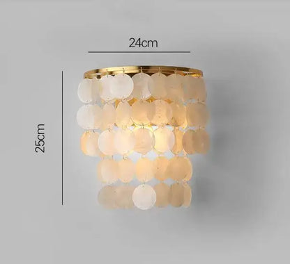 A tiered decorbites gold shell chandelier with cascading translucent iridescent discs on a polished gold frame