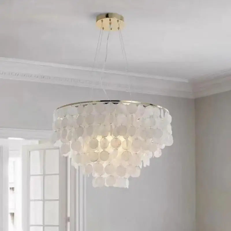 Modern gold shell chandelier with white multi-tiered circular shell discs and gold-toned ceiling mount for living room decorbites gold shell