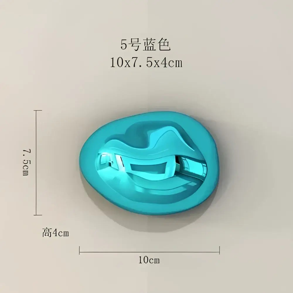 A glossy turquoise silicone mold shaped like a stylized face for modern gold and silver stone wall ornaments decor
