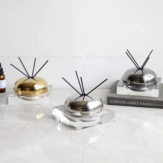 Modern gold and silver spherical aromatherapy diffuser with black reeds on clear acrylic base from decorbites golden geometry