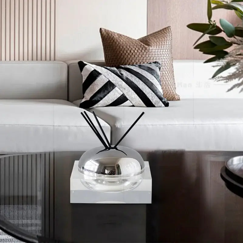 Shiny silver dome-shaped aromatherapy diffuser with black reeds on clear acrylic base for decorbites golden geometry decor