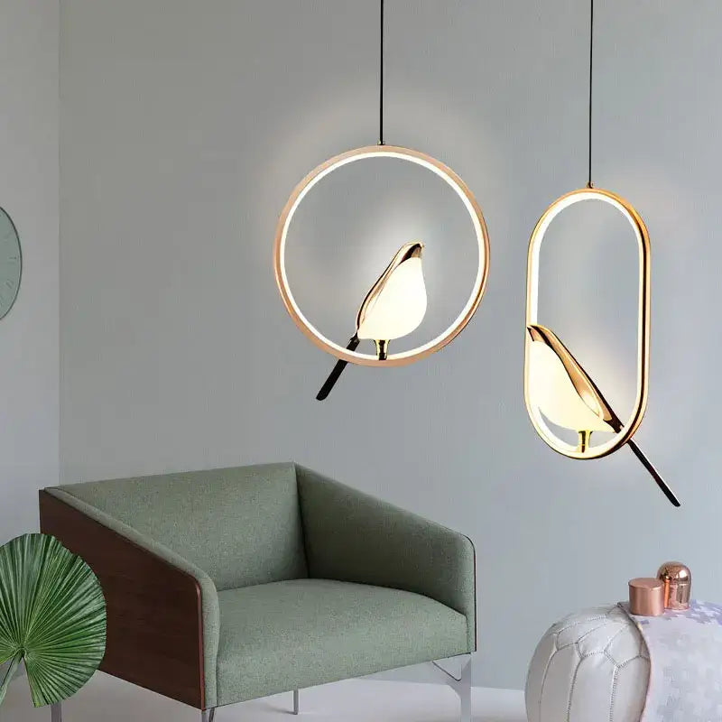 Two modern pendant lights with golden bird silhouettes and led bulbs in metallic finish for dining room use