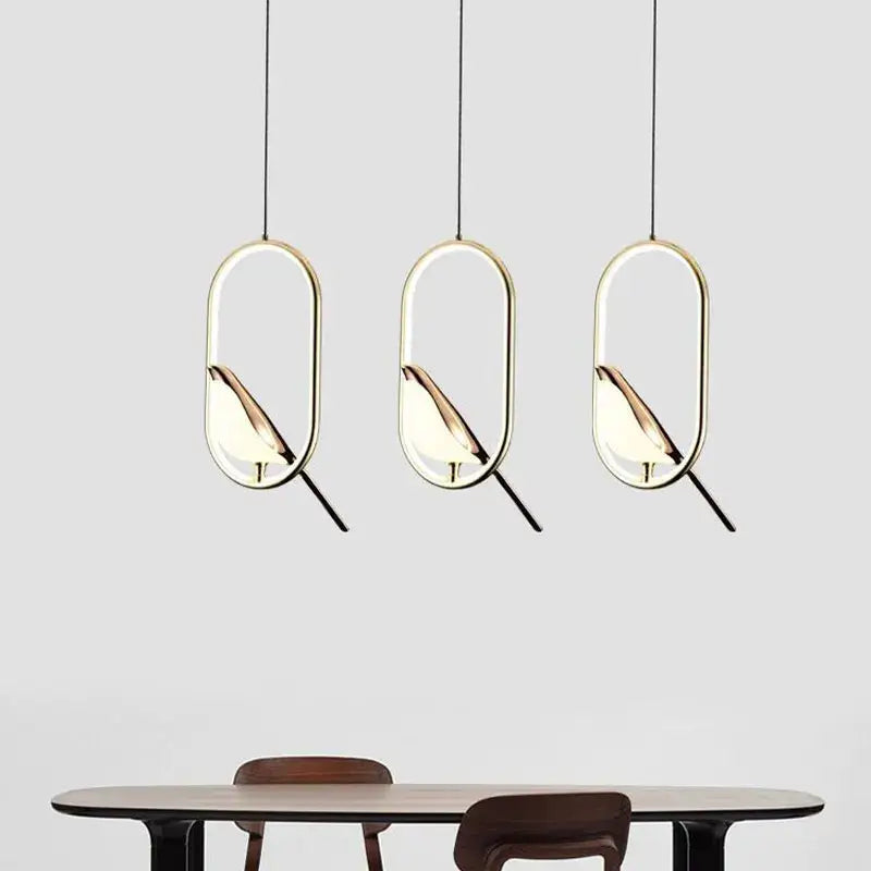 Three modern gold and silver pendant lights with metallic finish and bird silhouettes for dining room lighting area