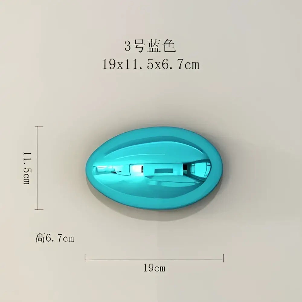 A sleek turquoise plastic device with integrated buttons as part of modern gold and silver metallic wall hanging ornaments