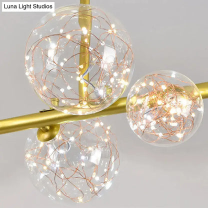 Modern gold spherical clear glass light fixture with three clear glass spheres and copper wire fairy lights for dining room