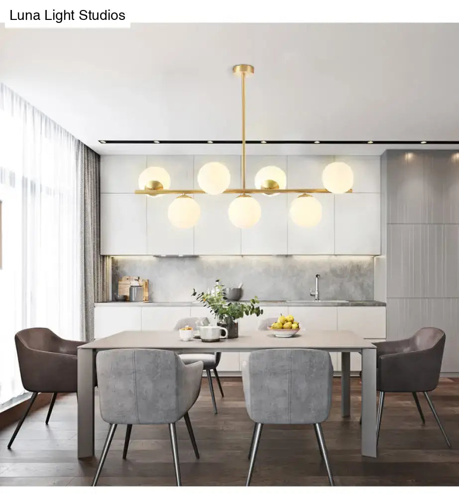 Modern gold-toned island ceiling light with six frosted glass spherical bulbs pendant lighting for dining room