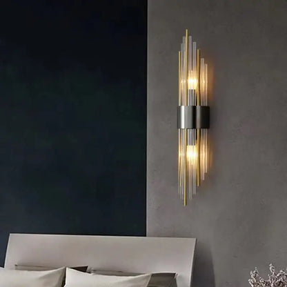 Modern gold stainless steel wall lamp with clear crystal rods and brushed metal band emitting warm light for bedroom sconce