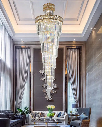 A towering multi-tiered modern gold stainless steel crystal chandelier with gold accents for staircase lighting