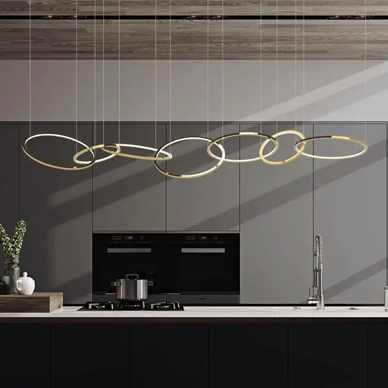 Modern gold stainless steel pendant lamp with circular interconnected rings above kitchen counter decorbites gold stainless