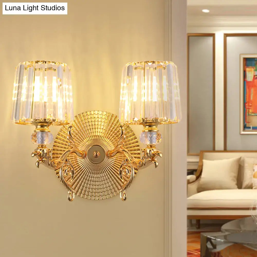 Modern gold tapered wall light fixture featuring an ornate sunburst design with two crystal-encased lights
