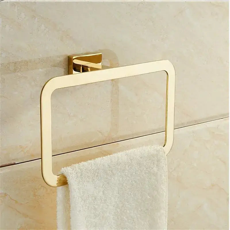 Modern gold towel ranger accessory rack with sleek gold-toned rectangular design mounted on tiled wall
