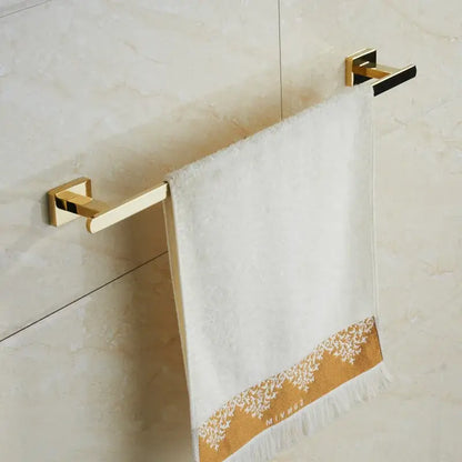 White towel with gold-trimmed lace and fringed edge hanging on modern gold towel ranger accessory rack