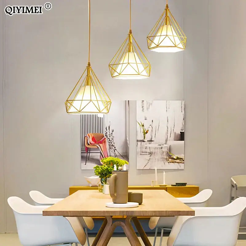 Modern gold triangle pendant lights with geometric faceted design hang above dining table decorbites gold triangle fixture