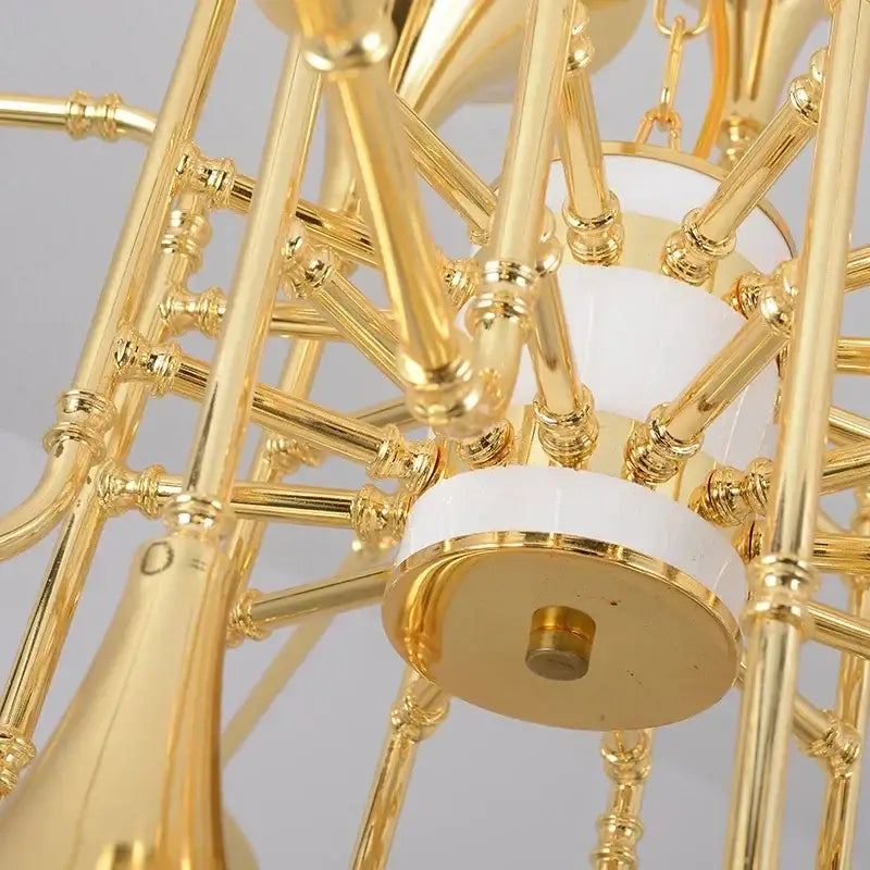 Modern gold trumpet pendant chandelier with intricate brass arms and white ceramic accents for dining room decorbites gold trumpet