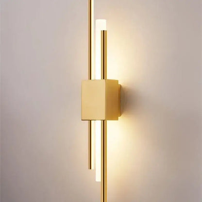 Modern gold tube wall sconce with sleek vertical rods and fabric diffuser emits warm ambient light for bedroom decorbites gold tube wall