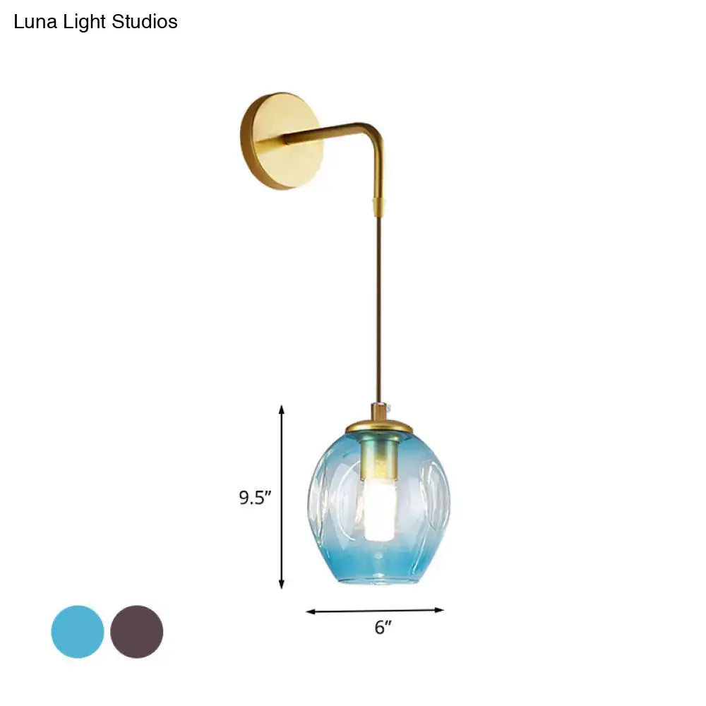 A sleek modern gold tulip wall lamp with brass finish and gradient blue glass shade for bedroom lighting