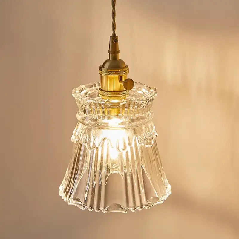 Modern gold wall lamp with clear glass shade featuring an intricately fluted pendant light and brass-finished socket for decorbites clear glass decor