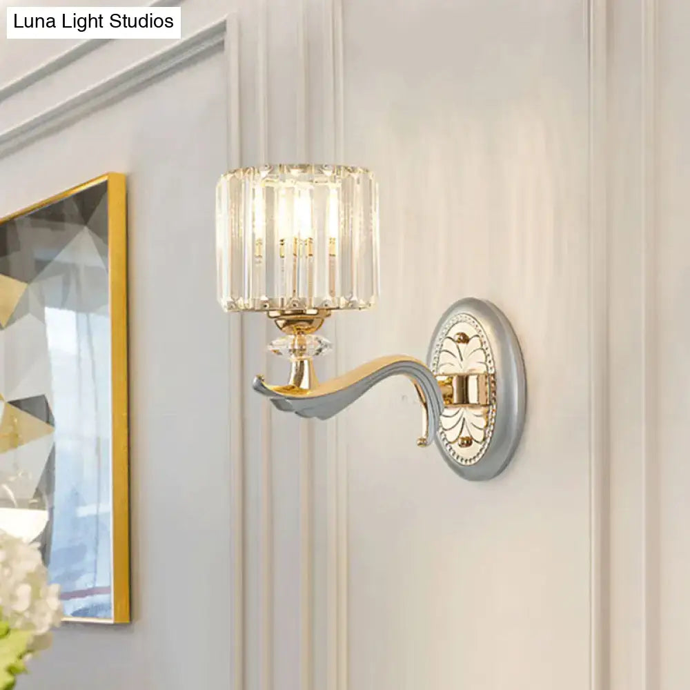 Elegant gold wall light with clear crystal shade and ornate backplate designed as a living room sconce
