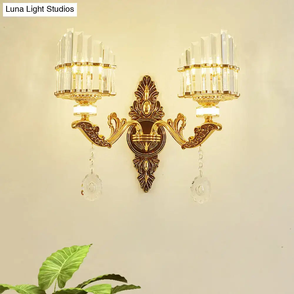 Modern gold wall mount light arc sconce with two crystal chandelier arms and dangling clear crystals for bedroom