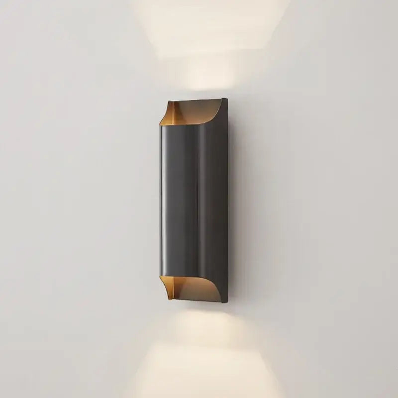 Modern black and gold wall sconce with sleek curved design, a minimalist wall lamp from decorbites copper brass collection