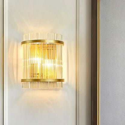 Modern gold wall sconce featuring vertical clear crystal rods designed for elegant hallway lighting