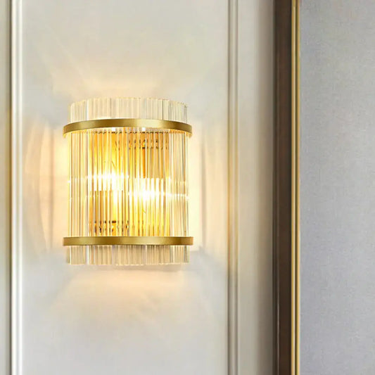 Modern gold wall sconce featuring vertical clear crystal rods designed for elegant hallway lighting