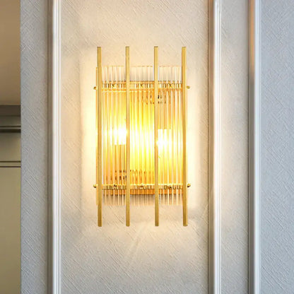 Modern gold wall sconce with clear crystal rods and a warm glowing light for elegant hallway lighting