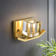 Modern gold wall sconce with cubic clear crystal faceted glass shade and polished metal frame for parlor lighting