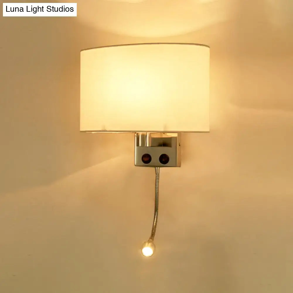 Modern gold wall sconce with a warm-toned fabric shade and adjustable reading light mounted on a metallic fixture