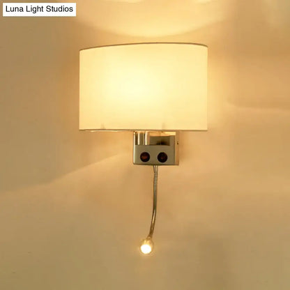 Modern gold wall sconce with a warm-toned fabric shade and adjustable reading light mounted on a metallic fixture