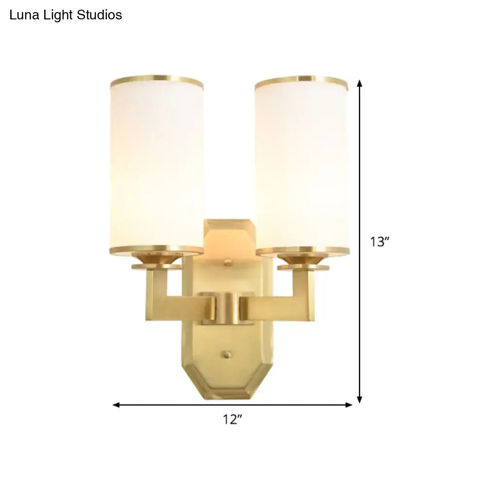 Modern gold wall sconce with opal glass cylindrical shades for bedroom lighting fixture with a gold finish