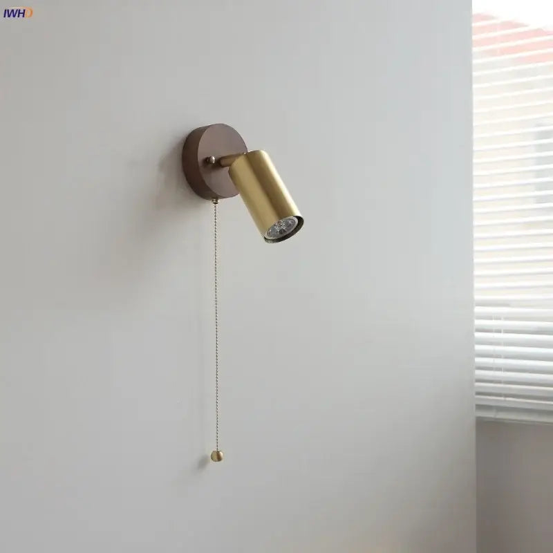 Modern gold walnut wall sconce with gold-finished circular base and pull chain switch for bedroom lighting