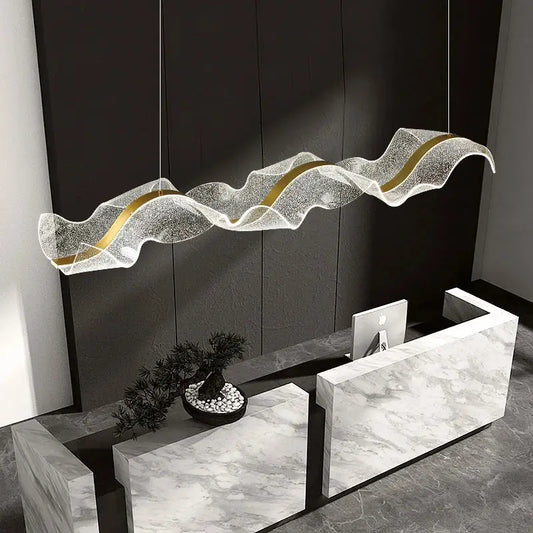 Modern pendant light with gold wave design featuring a translucent textured white acrylic body and gold accents