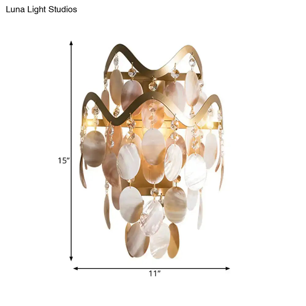Modern gold wave wired electric wall sconce with cream and gold shell accent and dangling crystal beads
