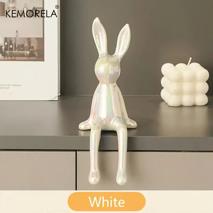 A sleek white ceramic sitting rabbit ornament with a glossy iridescent finish for modern living room decor