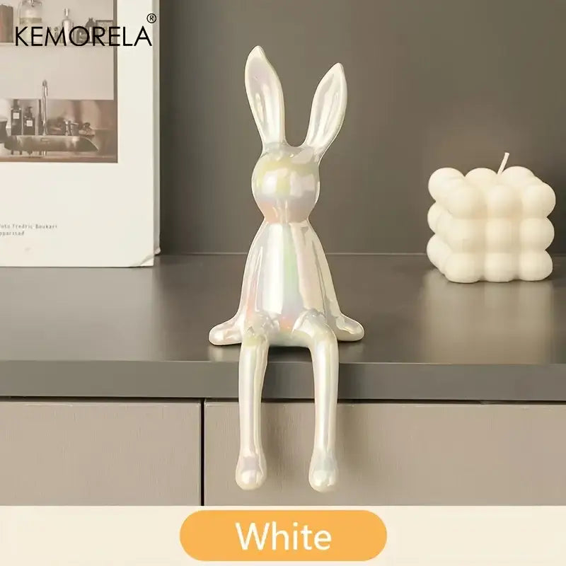 A sleek white ceramic sitting rabbit ornament with a glossy iridescent finish for modern living room decor