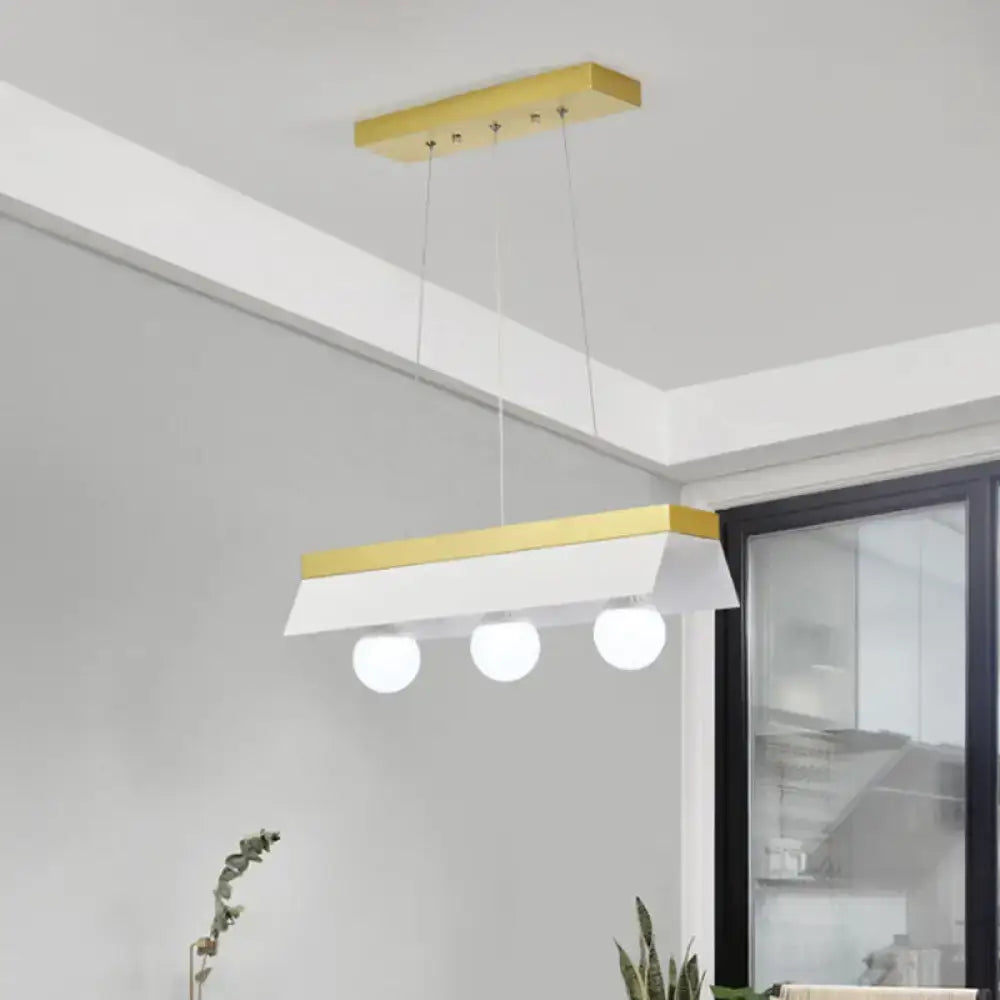 Modern rectangular pendant light with gold-accented frame and three white shade bulbs ideal for restaurant lighting
