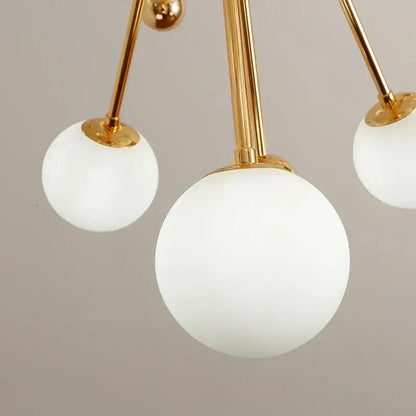 Modern golden acrylic molecule chandelier with gold-toned frame and three frosted glass globe shades for kitchen decorbites golden acrylic