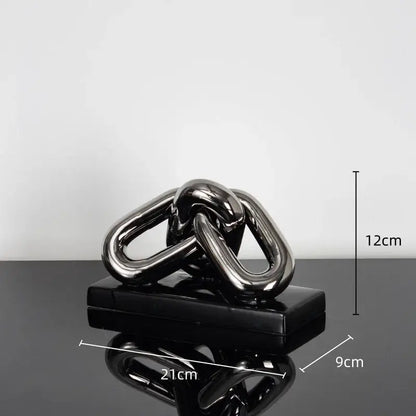 Shiny black metallic chain sculpture on matching base as a modern home decoration figurine for living room decor