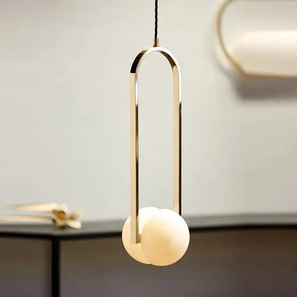 Modern pendant lights with a sleek gold-toned metal frame and off-white glass spheres by decorbites golden chandelier