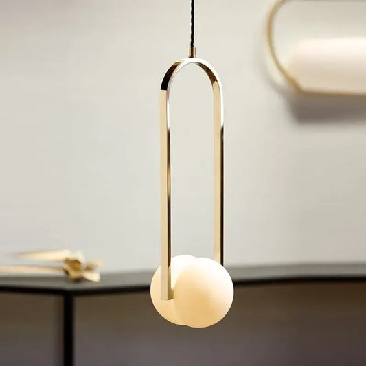 Modern pendant lights with a sleek gold-toned metal frame and off-white glass spheres by decorbites golden chandelier