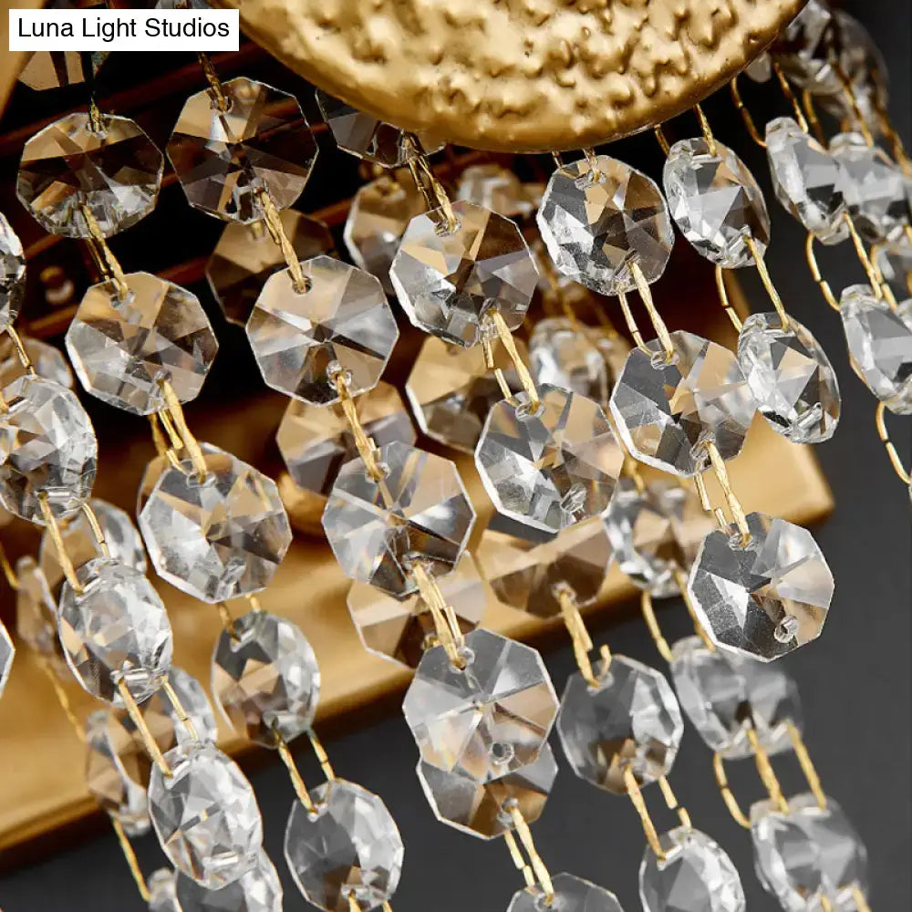 Clear faceted crystal beads hang from gold-toned chains on a modern golden egg wall mount light sconce