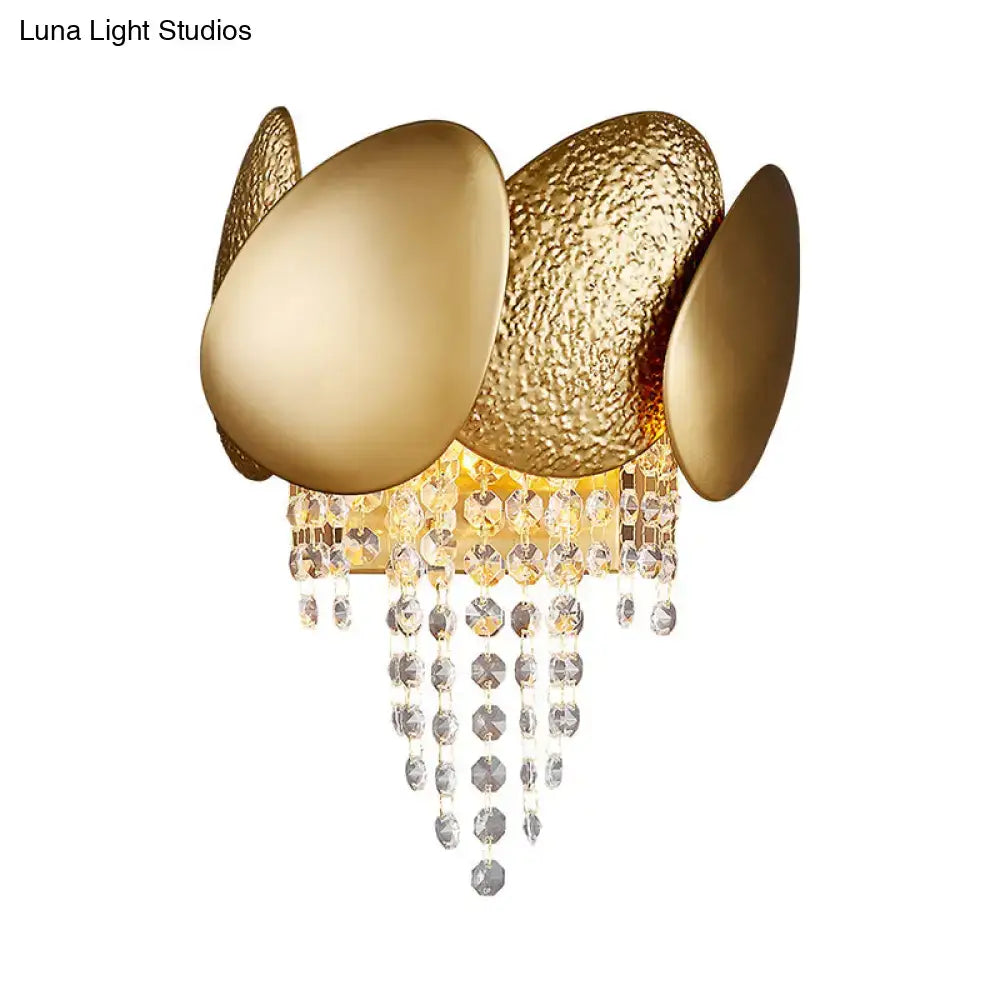 Modern golden egg wall mount light with textured and smooth oval panels and cascading crystal beads for bedroom