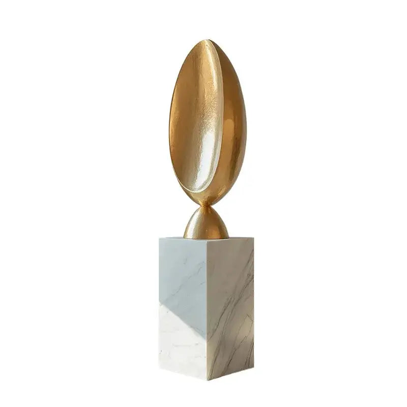 Golden geometric animal egg-shaped sculpture in metallic finish mounted on white marble pedestal for living room decor